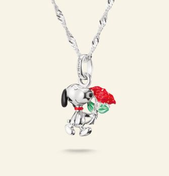 An einer silbernen Kette hängt ein Charm der Snoopy mit einer roten Rose darstellt.